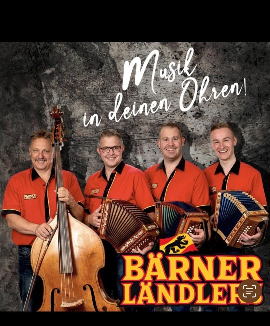 1754217912post_image14 Vier Musiker in roten Hemden spielen traditionelle Instrumente vor einer Wand mit Musik in deinen Ohren Schriftzug.