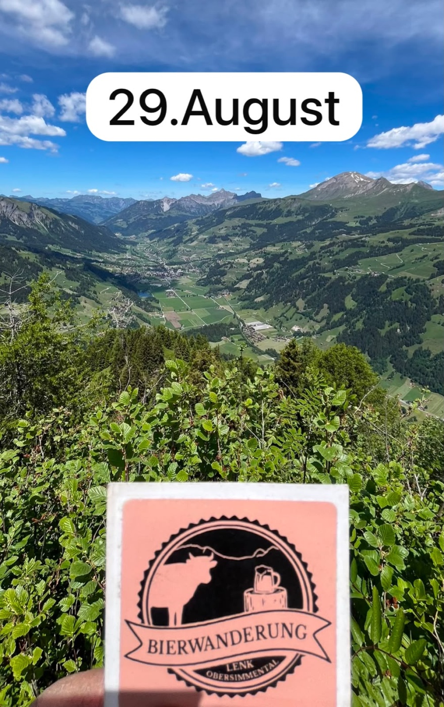 Blick auf grünes Tal und Berge bei Lenk, Obersimmental, mit Bierwanderungsplakat. Datum: 29. August.